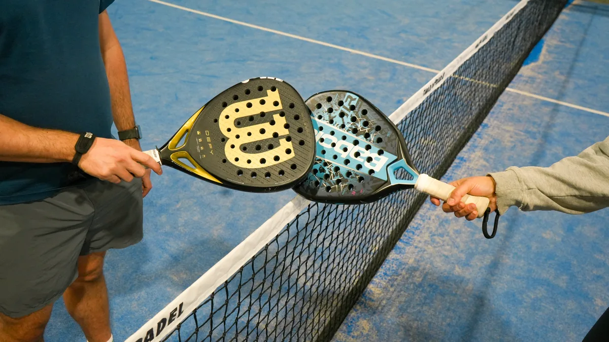 Padel rackets meeting over the net on a Smash Padel court